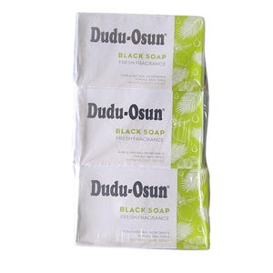 Puede incluir: Tres barras envueltas de jab&oacute;n negro Dudu-Osun. El embalaje blanco presenta el nombre de la marca y los detalles del producto en texto negro, con un dise&ntilde;o de hojas verdes y blancas en el lateral. El jab&oacute;n se anuncia como de fragancia fresca e ingredientes naturales.
