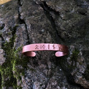 Brazalete vikingo forjado a mano: pieza poderosa y única hecha de cobre puro con los emblemas de "Thor" y "Odín".