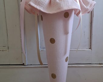 May include: A light pink fabric cone with gold glitter polka dots, featuring a ruffled top edge and a matching pink fabric closure at the opening. The cone is accented with thin, light-colored ribbons tied around the top section.