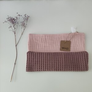 Puede incluir: Un pa&ntilde;o de cocina de tejido de gofre rosa y marr&oacute;n con una etiqueta "Tichel".