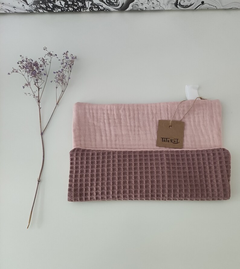 Puede incluir: Un pa&ntilde;o de cocina de tejido de gofre rosa y marr&oacute;n con una etiqueta "Tichel".