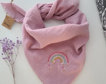 May include: A pink muslin bandana with a rainbow and hearts embroidered on it. The bandana is tied in a knot and the tag "TaterTot" is visible.