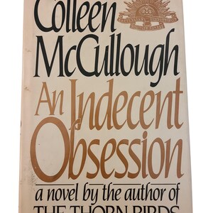 Puede incluir: Un libro de bolsillo vintage de Colleen McCullough, titulado "An Indecent Obsession". La portada es de color beige claro con letras negras y marrones. El libro también presenta un emblema y la obra anterior del autor, "The Thorn Birds".