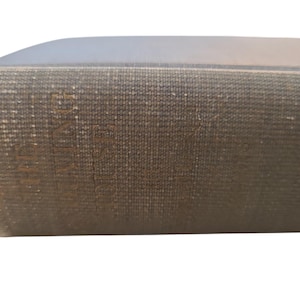 Puede incluir: Primer plano de un libro marrón con una cubierta texturizada. El título "ATLAS" es visible en el lomo.