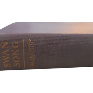 May include: A brown hardcover book with the title "Swan Song" and the author "Galsworthy" printed in gold lettering.