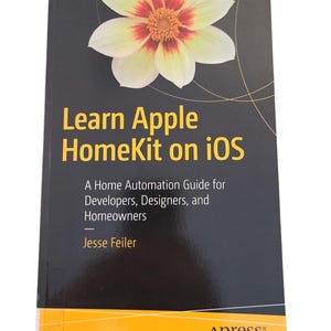May include: A book titled "Learn Apple HomeKit on iOS" with a black cover and a large flower graphic. The book is a home automation guide for developers, designers, and homeowners, written by Jesse Feiler. The Apress logo is at the bottom.