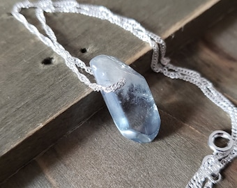 Könnte beinhalten: Eine silberne Kettenkette mit einem großen, hellblauen, facettierten Kristallanhänger.