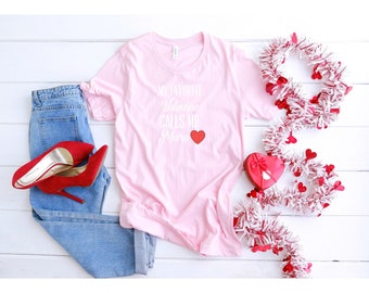 Könnte beinhalten: Rosafarbenes T-Shirt mit dem Text "Mein Lieblings-Valentinstag nennt mich Mama" und einem roten Herzen.