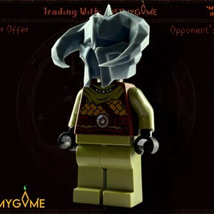 May include: A Lego minifigure wearing a grey horned helmet and a red and yellow torso. The figure has green legs and black hands. The background is dark with text that reads "Trading With JUSTMYGVME" and "*MINIFIG NOT INCLUDED."