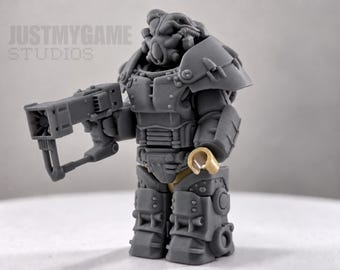 May include: A gray plastic minifigure wearing bulky power armor with a helmet, shoulder pauldrons, and chest plating. The figure holds a rectangular blaster weapon in its right hand and has a tan hand on the left. Text reads JUSTMYGAME STUDIOS.