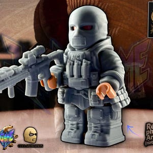 Può includere: Action figure grigia di un soldato in tenuta tattica, con un fucile. La figura indossa un passamontagna e ha le mani arancioni e gli occhi rossi. L'immagine include il testo che dice "Real physical Artwork (not a render)" e "ADVANCED".