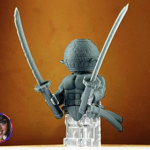 Puede incluir: Una figura de guerrero gris con un casco y dos espadas. La figura sostiene las espadas en una postura defensiva. La figura está sobre una base transparente. El fondo es un degradado de naranja y marrón.