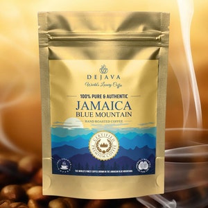 Puede incluir: Una bolsa dorada de café Dejava Jamaica Blue Mountain tostado a mano. La bolsa presenta el texto "100% Pure & Authentic" y "Certified Premium Coffee". El diseño incluye una cordillera y un amanecer.