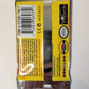 May include: Sealed Pok&eacute;mon trading card game pack with yellow and silver packaging. Features the Wizards of the Coast logo, Nintendo seal, and text including "Expert Level". The pack includes the ISBN 1-57530-748-7.