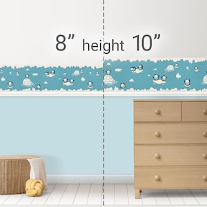 May include: A blue and white penguin themed wallpaper border with a repeating pattern of penguins, icebergs, and snowflakes. The border is 8 inches tall and 10 inches wide.
