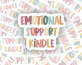 May include: A sticker with the words "Emotional Support Kindle" in a colorful, hand-drawn font. The sticker is on a white background with a repeating pattern of the same words in a smaller font.