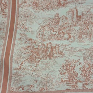 Può includere: Un tessuto con un design toile de Jouy nei toni del bianco e corallo. Il motivo raffigura una scena pastorale con castelli, alberi e animali. Il tessuto ha un bordo corallo con strisce verticali.