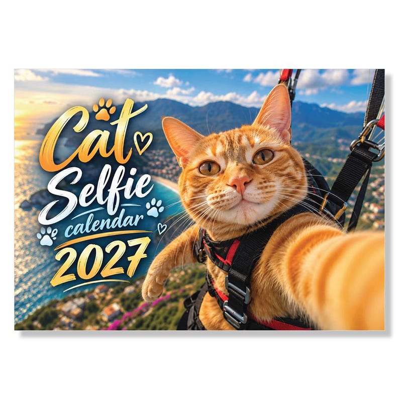 May include: A 2027 wall calendar featuring an orange tabby cat wearing a black and red harness while paragliding. The text reads Cat Selfie calendar 2027, accompanied by paw print and heart icons, set against a coastal mountain landscape background.