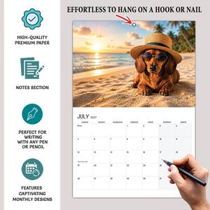 May include: A 2027 wall calendar featuring a photograph of a dachshund wearing a straw hat and round sunglasses on a beach at sunset. The calendar includes a grid for July 2027, a notes section, and text stating, "EFFORTLESS TO HANG ON A HOOK OR NAIL."