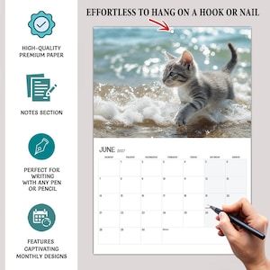 May include: A 2027 wall calendar featuring a gray tabby kitten walking through ocean waves. The calendar includes a notes section, a hole for hanging, and a grid for June 2027. Text includes EFFORTLESS TO HANG ON A HOOK OR NAIL, HIGH-QUALITY PREMIUM PAPER, NOTES SECTION, PERFECT FOR WRITING WITH ANY PEN OR PENCIL, and FEATURES CAPTIVATING MONTHLY DESIGNS.