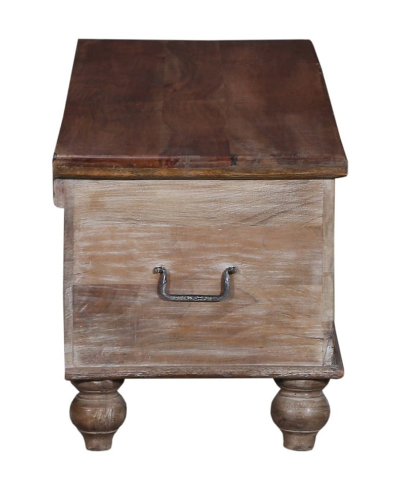 May include: A whitewashed wooden storage chest with a dark brown wood top and a metal handle. The chest has four turned legs.