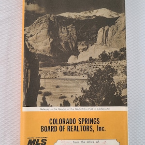 May include: A vintage map of Colorado Springs, featuring a sepia-toned image of Pikes Peak and the Garden of the Gods. The map is labeled "Official Arrow Map" and includes text from the Colorado Springs Board of Realtors.