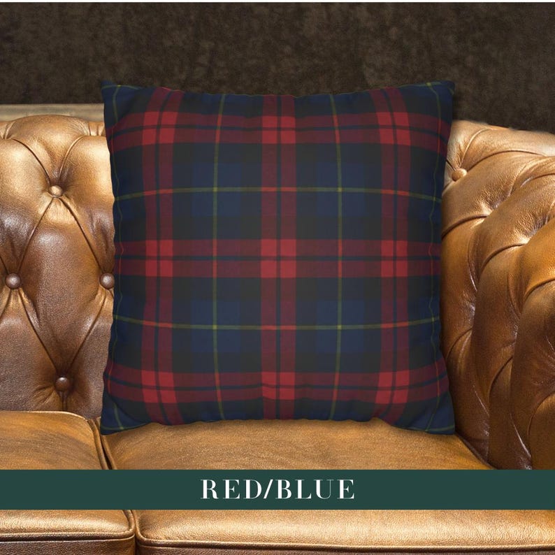 May include: A square throw pillow featuring a classic plaid pattern with intersecting lines in deep red, dark navy blue, and thin yellow accents. The fabric displays a symmetrical tartan design across the entire surface of the cushion.