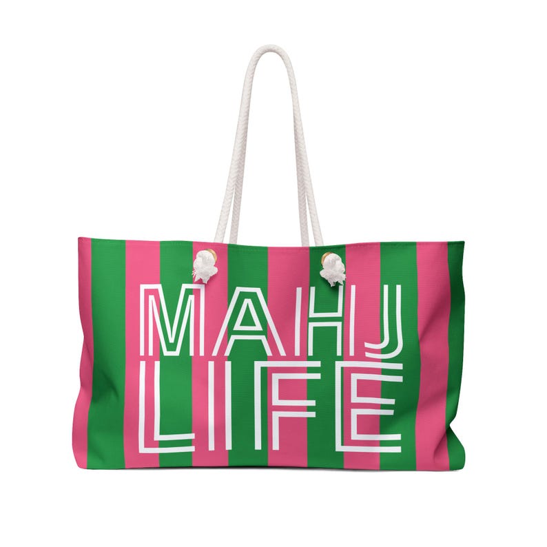 May include: A large tote bag with a vertical striped pattern in pink and green. The bag features the white text "MAHU LIFE" and has white rope handles.