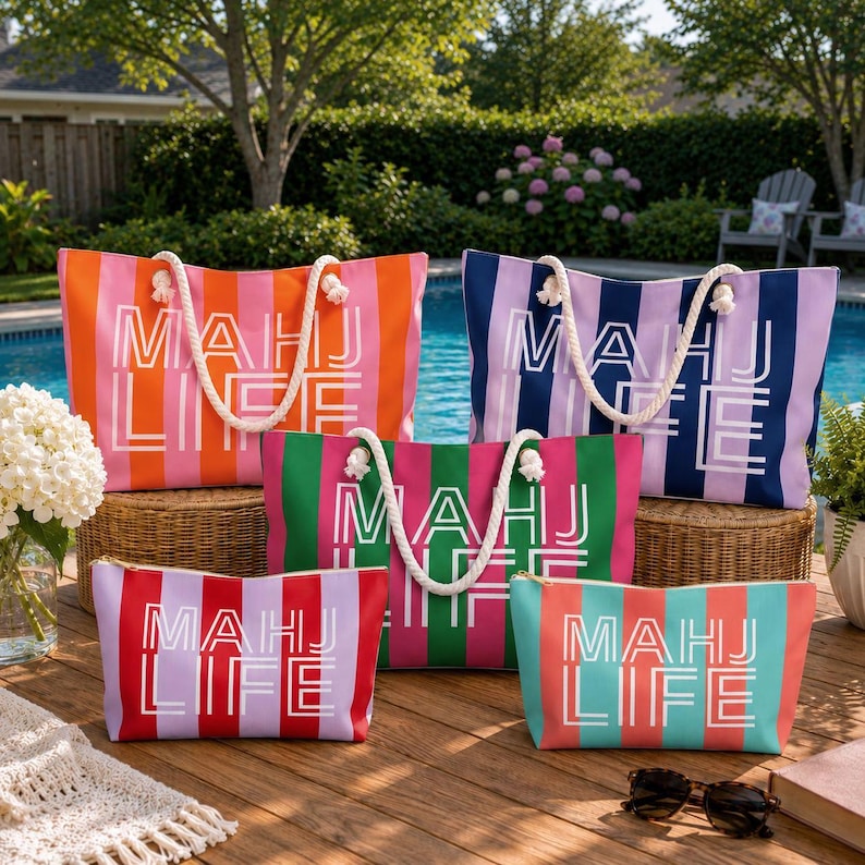 May include: A collection of striped tote bags and matching zippered pouches in various colors, including orange, pink, green, and blue. Each bag features a white rope handle and the text "MAHJ LIFE". The bags are arranged on a wooden deck near a pool.