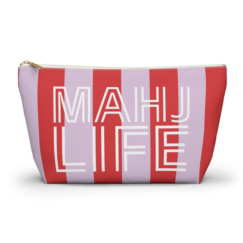 May include: A zippered pouch with a red and lavender striped pattern. The words "MAHJ LIFE" are printed in white block letters across the front. The pouch has a gold-colored zipper.