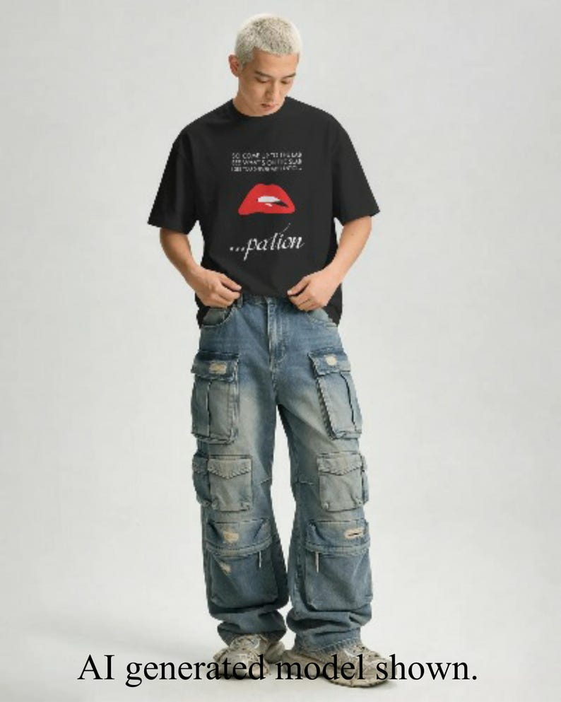 May include: A black short-sleeved t-shirt featuring a graphic of red lips and the text "...pation" below, paired with loose-fitting blue denim cargo trousers that have multiple large pockets and distressed details on the fabric surface.