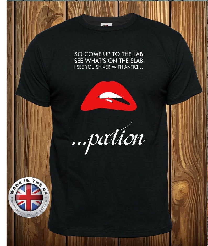 May include: A black short-sleeved t-shirt featuring a graphic of bright red lips with white teeth. The text reads: SO COME UP TO THE LAB SEE WHAT'S ON THE SLAB I SEE YOU SHIVER WITH ANTICI... ...pation. A circular badge with the UK flag is in the corner.
