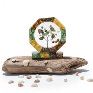 May include: A decorative tree sculpture with a wire tree design and green and brown stones, set within a multi-colored resin frame. The sculpture is mounted on a piece of driftwood, with small seashells scattered around it.