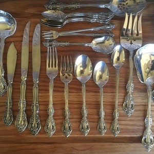 May include: A set of silver flatware with ornate handles. The set includes forks, spoons, and a butter knife.