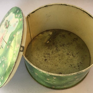 May include: A vintage green and white tin box with a floral design and the text "April Showers" on the lid. The lid is open and the inside of the box is visible.