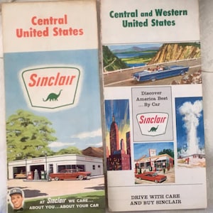 May include: Two vintage Sinclair gas station brochures. One titled "Central United States" and the other "Central and Western United States." Both feature illustrations of cars, landscapes, and the Sinclair dinosaur logo. The brochures are in good condition.