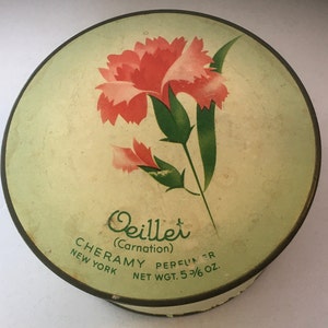 May include: A round, green and white vintage powder compact with a pink carnation flower design. The text on the compact reads "Oeillet (Carnation) CHERAMY PERFUMER NEW YORK NET WGT. 5 3/6 oz."