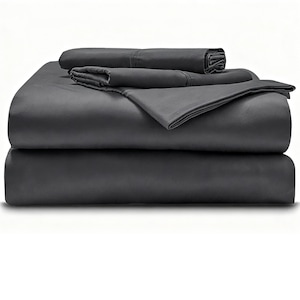 Puede incluir: Un juego de sábanas de color gris carbón oscuro dobladas en una pila ordenada. La colección incluye una sábana encimera, una sábana bajera y fundas de almohada, todas con una tela lisa de color sólido y dobladillos cosidos en los bordes.