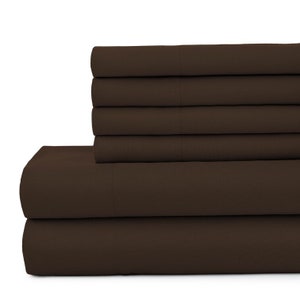 May include: A stack of six brown fitted sheets. The sheets are made of a soft, comfortable fabric and are perfect for any bedroom.