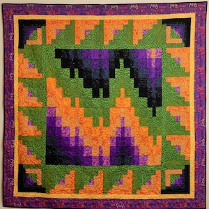 Puede incluir: Una colcha cuadrada con un patrón de cabaña de troncos en tonos naranja, verde, morado y negro. El diseño incluye un motivo central de murciélago y un borde de tela morada estampada con el texto repetido "Haunt" y "Fun" en amarillo.