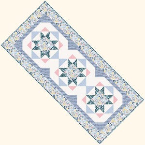 Peut inclure: Un chemin de table bleu et blanc avec un motif floral et trois motifs en forme d'étoile au centre. Les étoiles sont faites d'un tissu vert foncé à pois blancs et sont entourées de triangles roses et blancs.