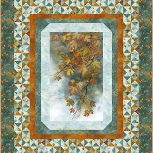 Puede incluir: Una colcha con una imagen central de una rama de hojas de otoño en tonos de naranja, amarillo y marrón. Las hojas están rodeadas por un borde de triángulos azules y naranjas, y el borde exterior es un patrón de hojas verdes.