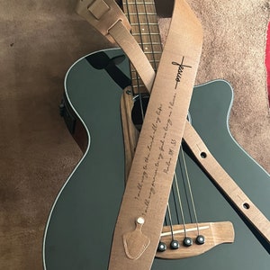 May include: A brown leather guitar strap with the text "I will sing to the Lord all my life" and "Psalms 111:1-3" engraved on it. The strap also has the word "Jesus" engraved on it.