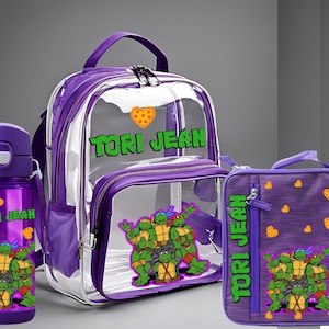 Könnte beinhalten: Ein durchsichtiger lila Rucksack mit einer Lunchbox und einer Wasserflasche. Der Rucksack hat ein transparentes Frontfach mit einem Teenage Mutant Ninja Turtles-Motiv und dem Namen "TORI JEAN" darauf gedruckt. Die Lunchbox und die Wasserflasche haben ebenfalls das gleiche Motiv und den gleichen Namen.