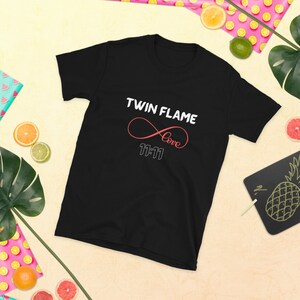 May include: Black t-shirt with the text "Twin Flame" and an infinity symbol with the word "love" inside. The number "11:11" is below the symbol.