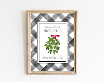 May include: A printable sign with a black and white checkered background. The sign says "Farm Fresh Mistletoe" and "Pick Your Own". A green mistletoe sprig with a red bow is illustrated in the center.