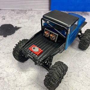 Pode incluir: Caminh&atilde;o de brinquedo preto com uma ca&ccedil;amba preta e uma c&eacute;lula de combust&iacute;vel vermelha. O caminh&atilde;o tem duas ventoinhas pretas na parte de tr&aacute;s e pneus pretos.