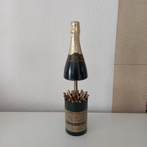 champagne bottle cigarette holder ART DECO WHITE STAR CIGARETTE DISPENSER IN THE SHAPE OF A CHAMPAGNE No two pieces are exactly alike Mariposa Champagne Bottle Napkin Weight