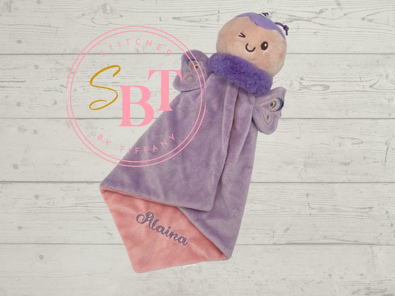 May include: Purple and pink baby security blanket with a butterfly plush toy attached. The blanket has the name "Alaina" embroidered on it.