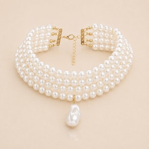 May include: A multi-strand pearl choker necklace with a gold-tone clasp and a large, irregular pearl pendant. The necklace features five strands of round, white pearls. The clasp and connecting elements are gold-colored.